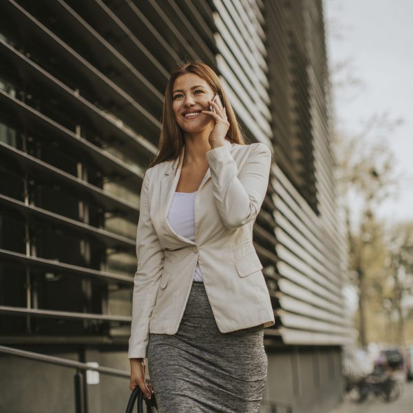 Businesswoman talking on the phone near office building